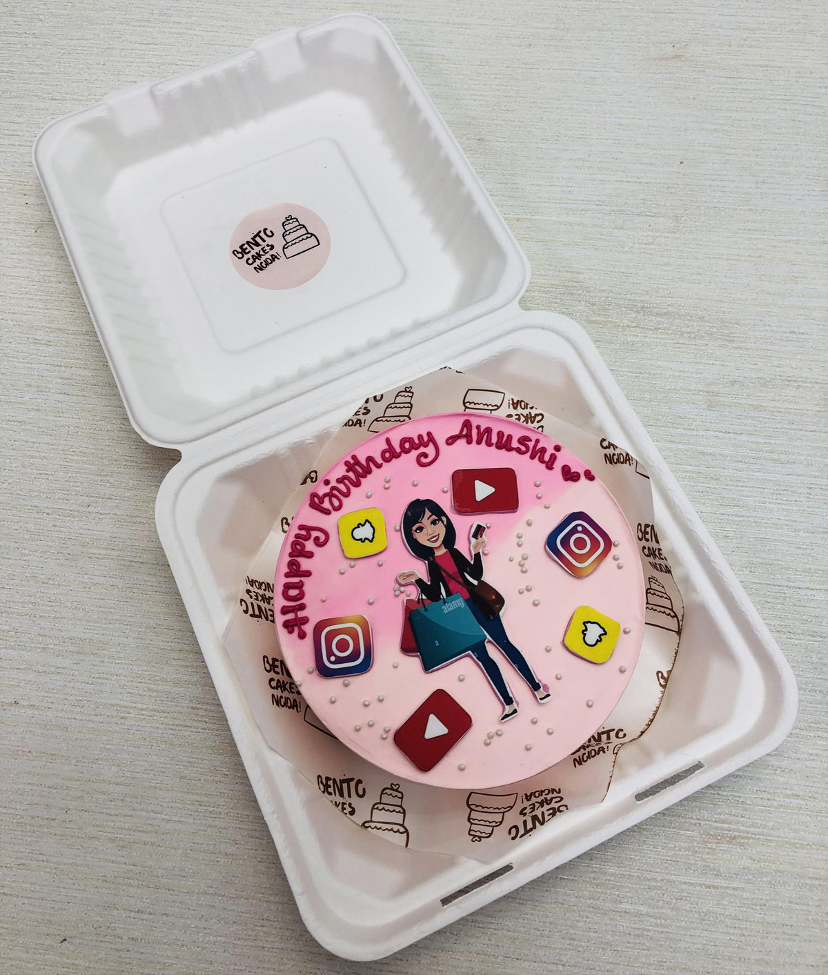 Aesthetic pink bento cake with a shopaholic, social media addicted girls birthday theme on it.