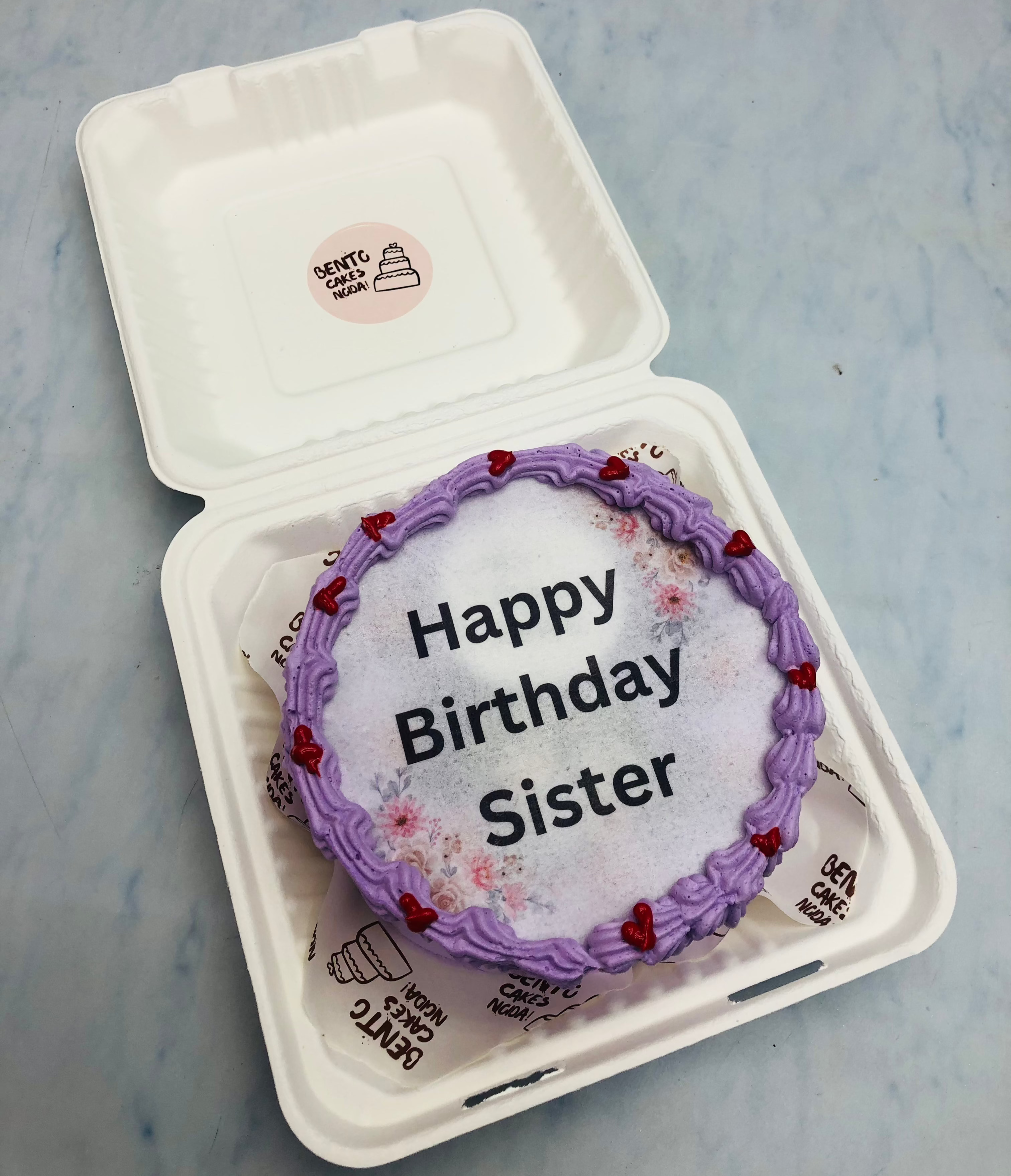 A purple fire bento cake with "Happy Birthday Sister" written on fire paper.