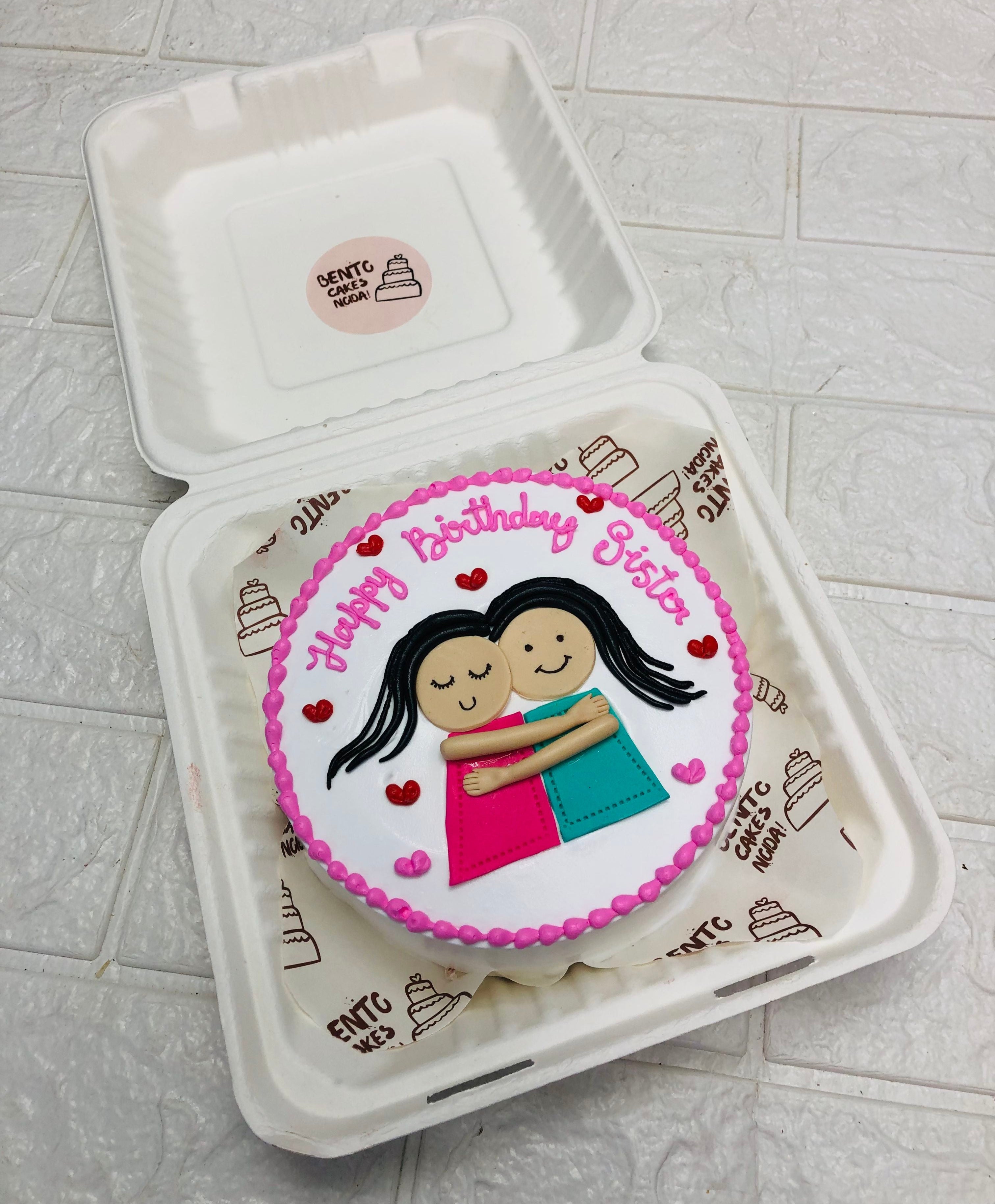 A white bento cake having 2 sister designed with fondant and celebrating birthday.