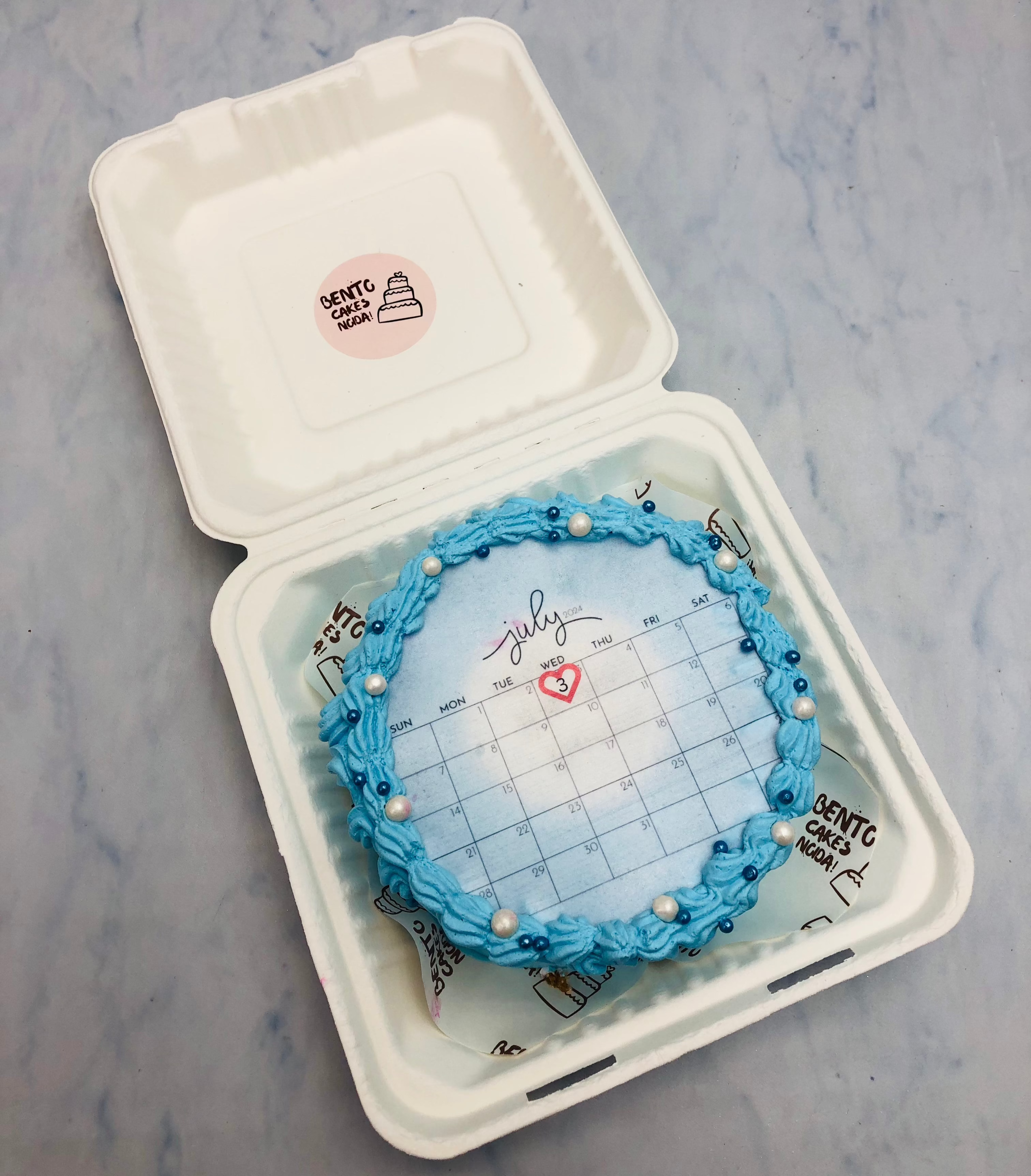 A light blue truffle fire bento cake with july calendar theme.