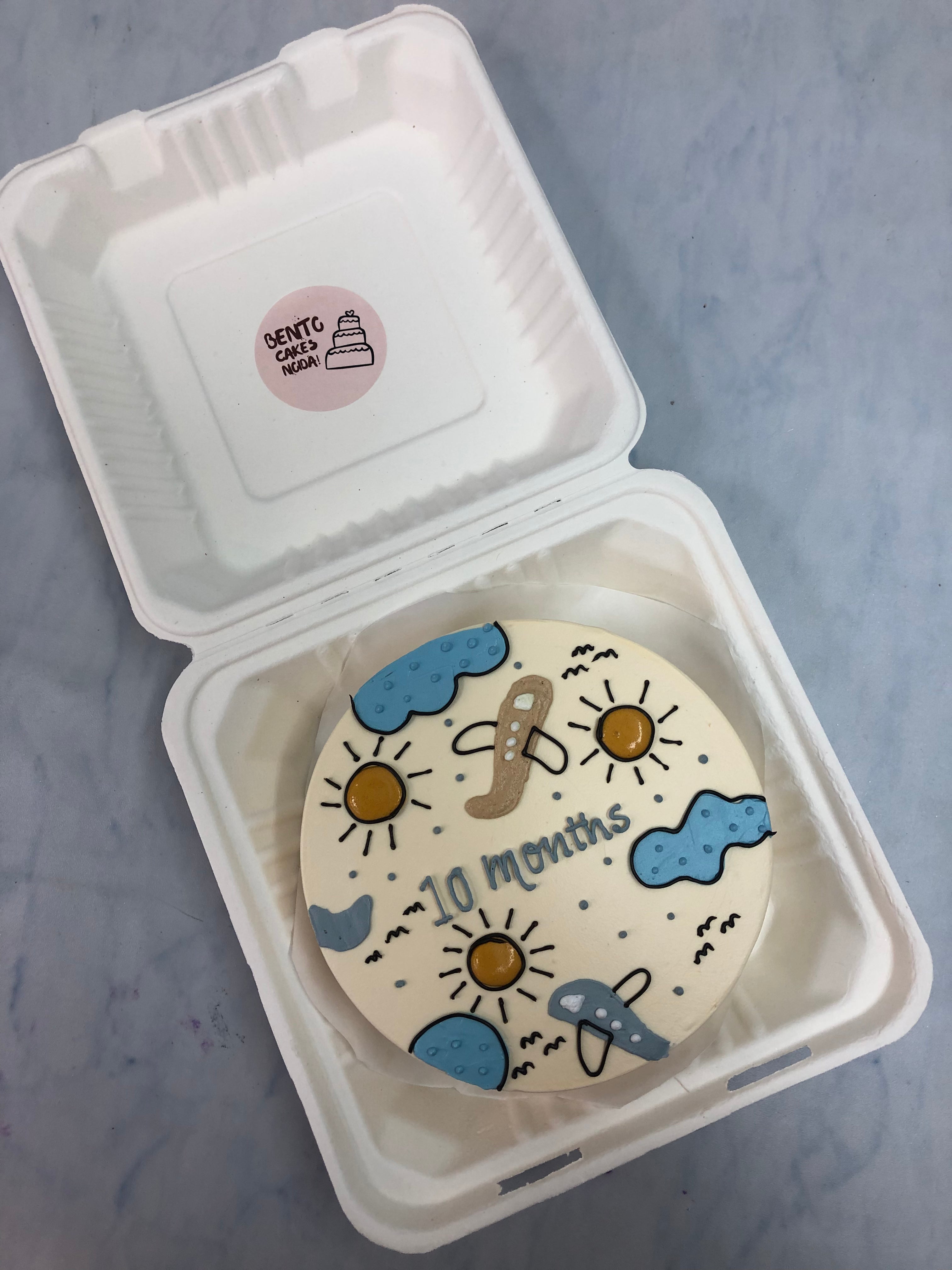 An off white cake decorated with flight, clouds and sun desibns on it.