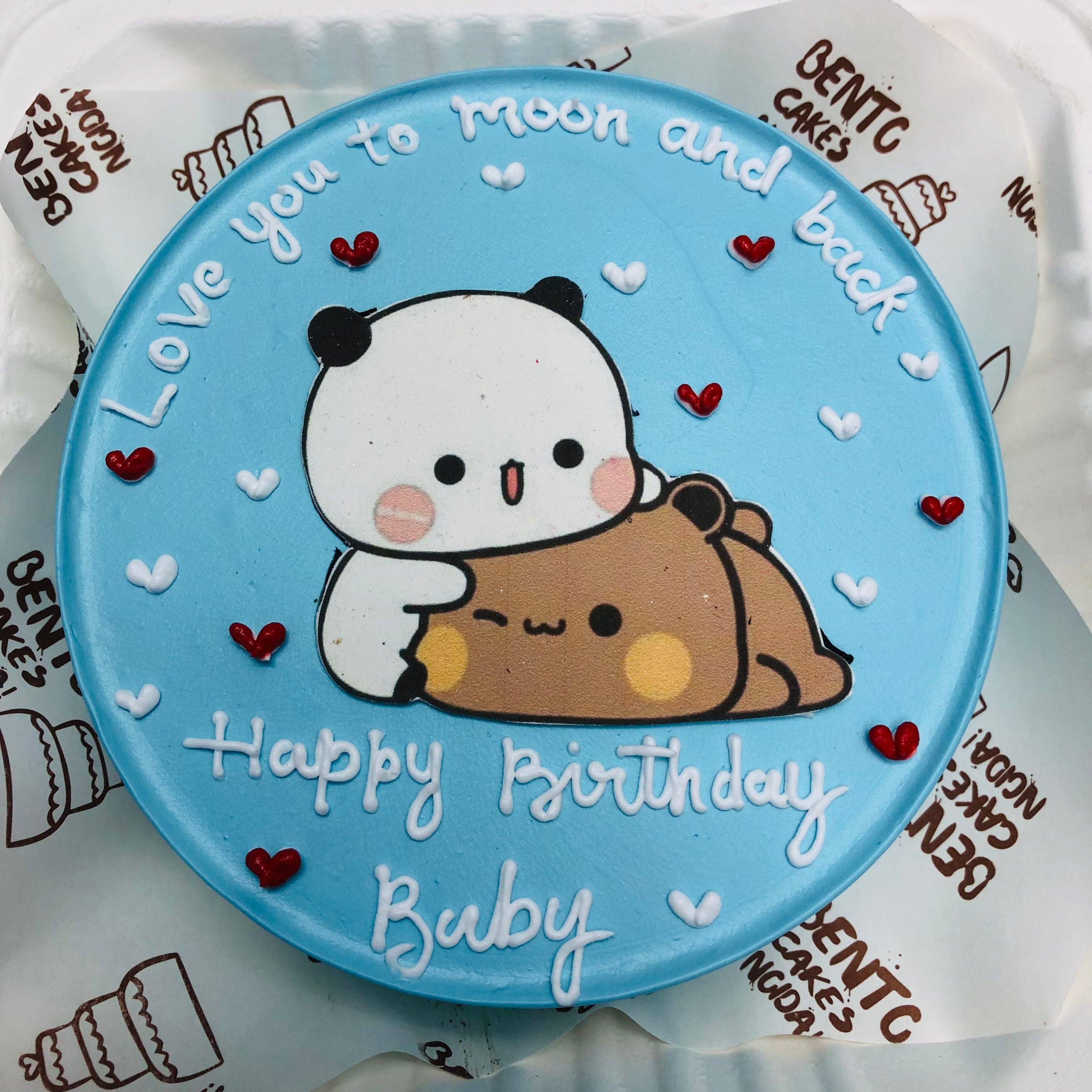 A shiney blue bento cake with sleepy bubu dudu character with red and white hearts design.