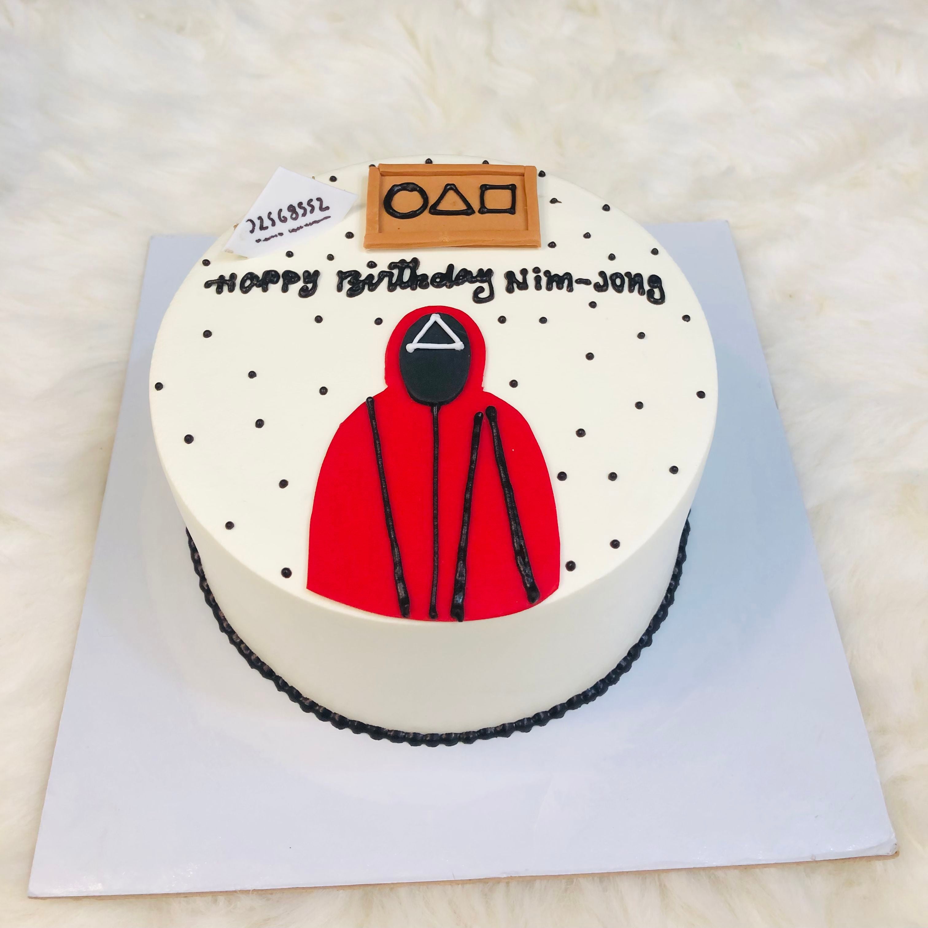 A birthday cake adorned with a red hoodie and a playful black and white polka dot pattern.