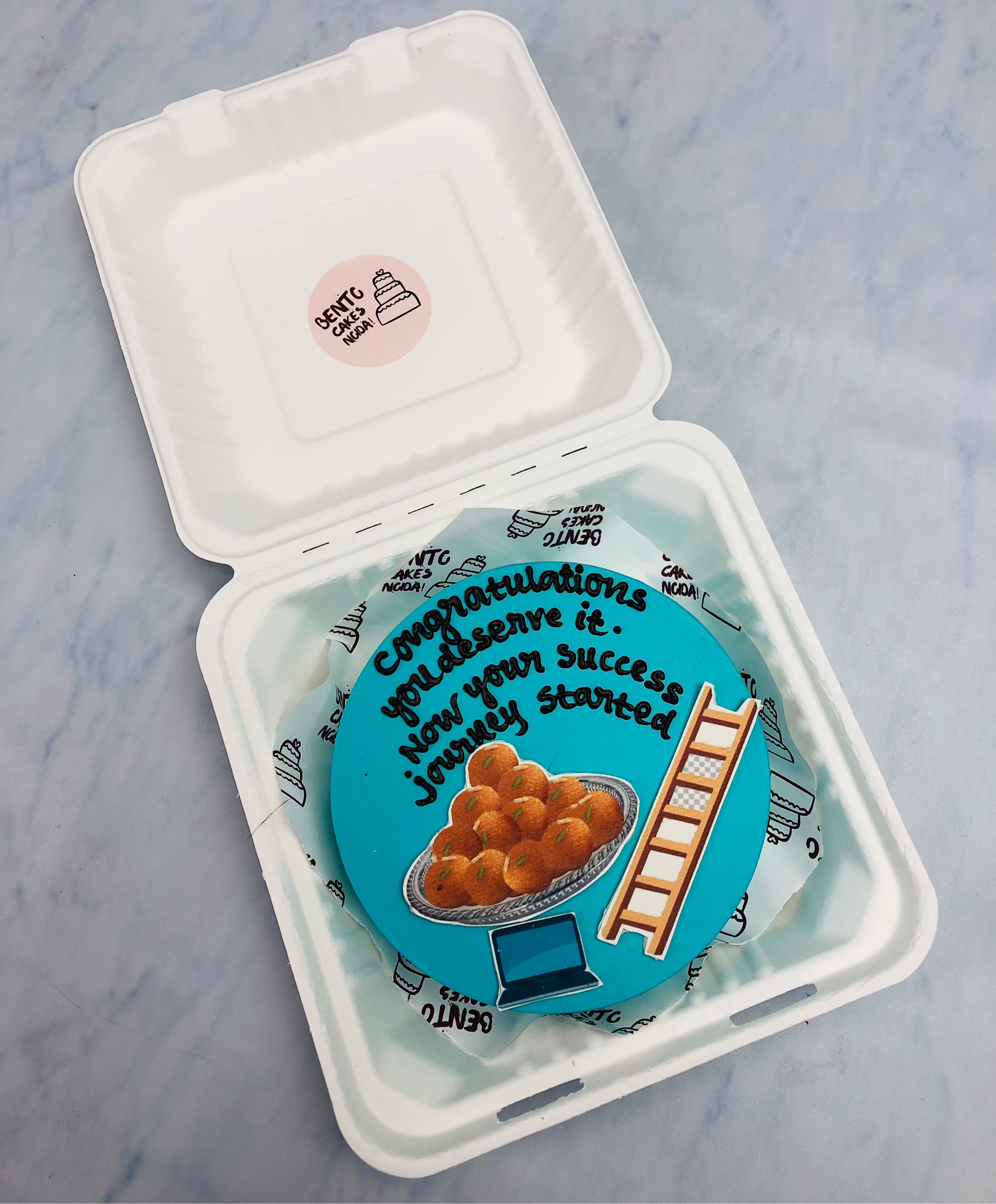A light blue bento cake is designed for new success jorney starting theme with sweets and a ladder print.