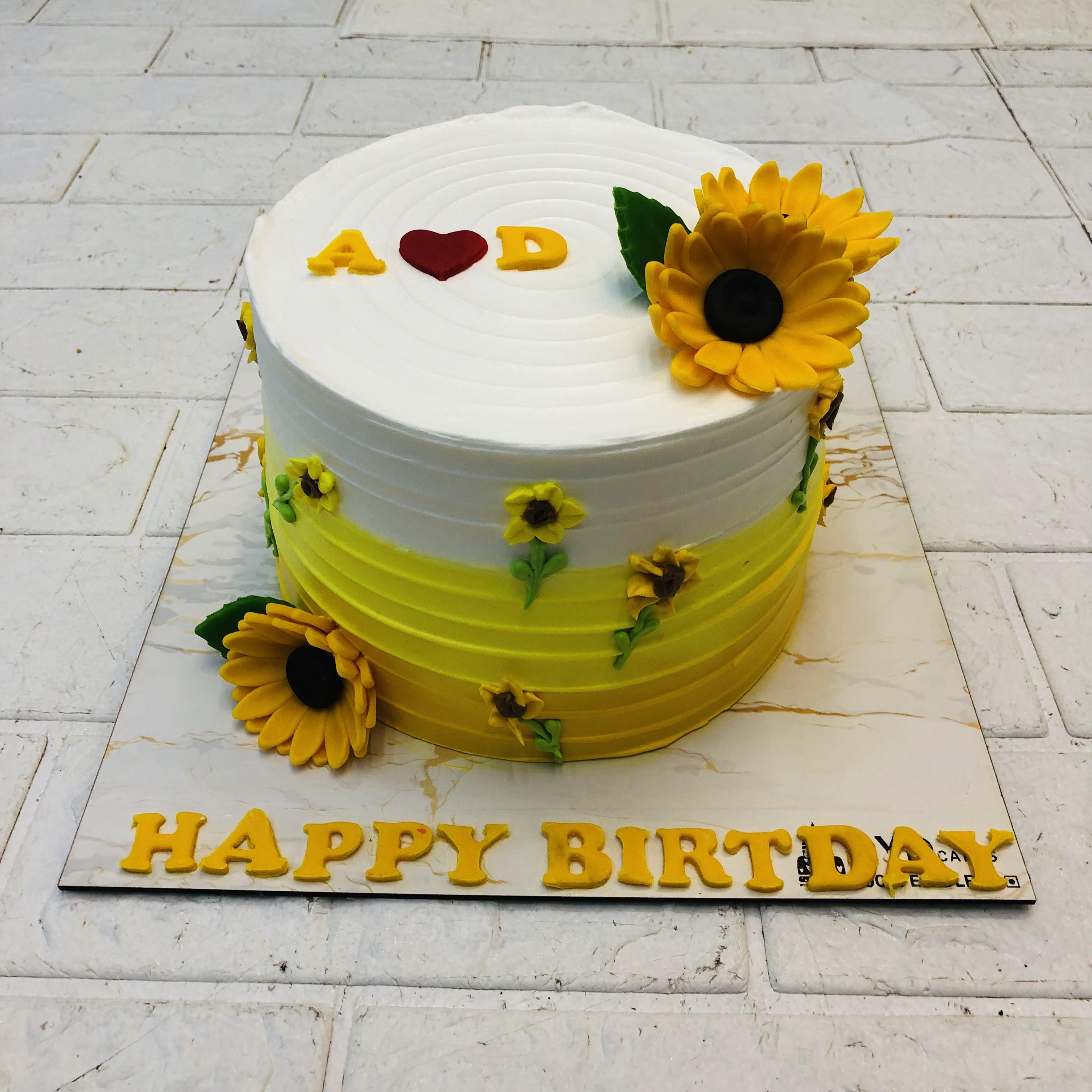 A white and yellow combination cake with yellow fondant sunflowers design for birthday.