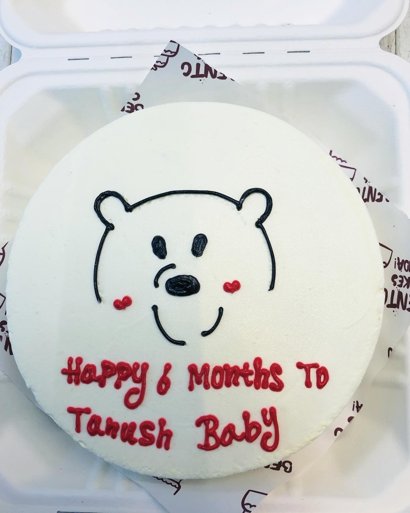 A white bento cake with a bear face design and a happy 6 months text.