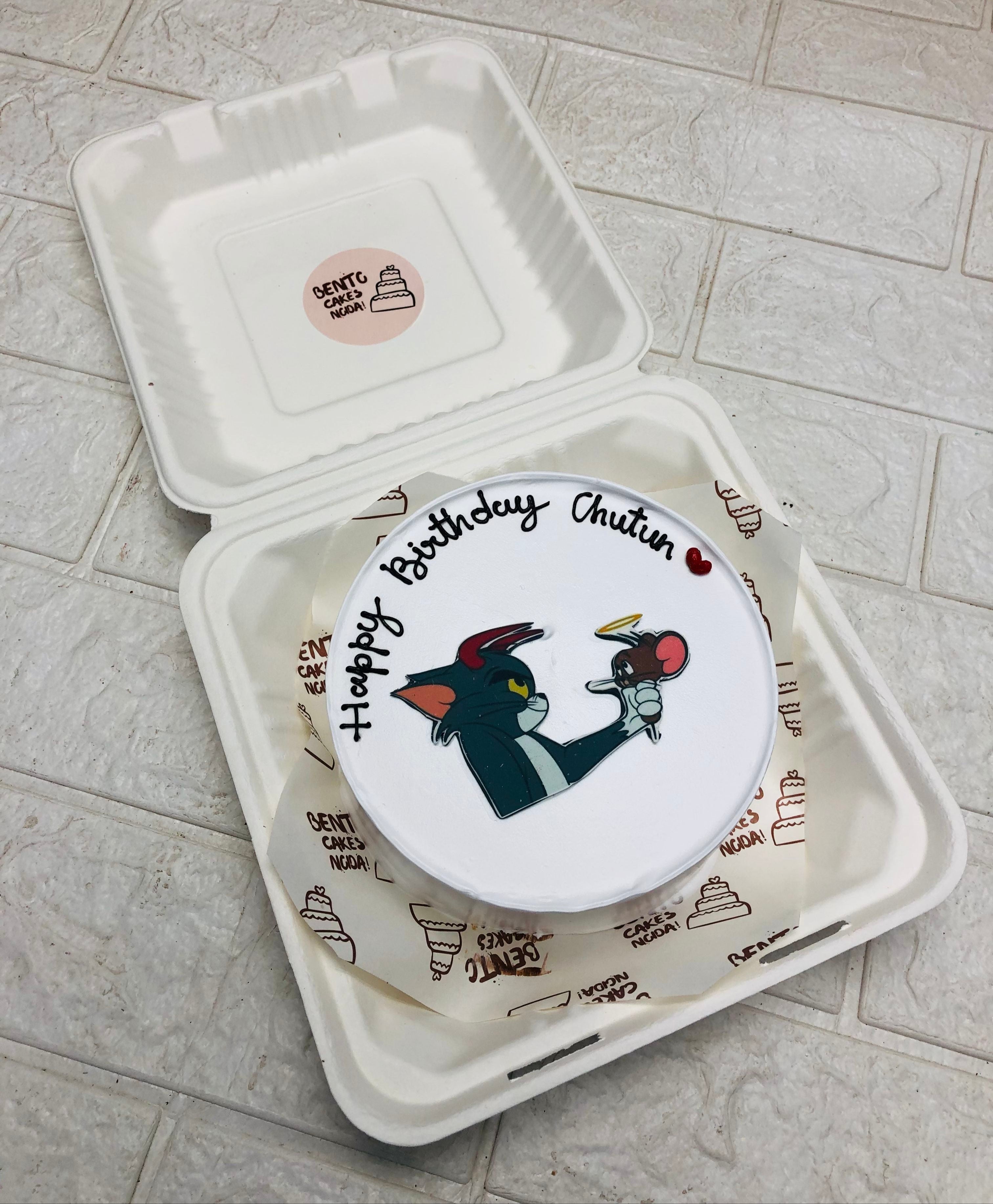 A white bento cake having Tom & jerry cartoon print for birthday.
