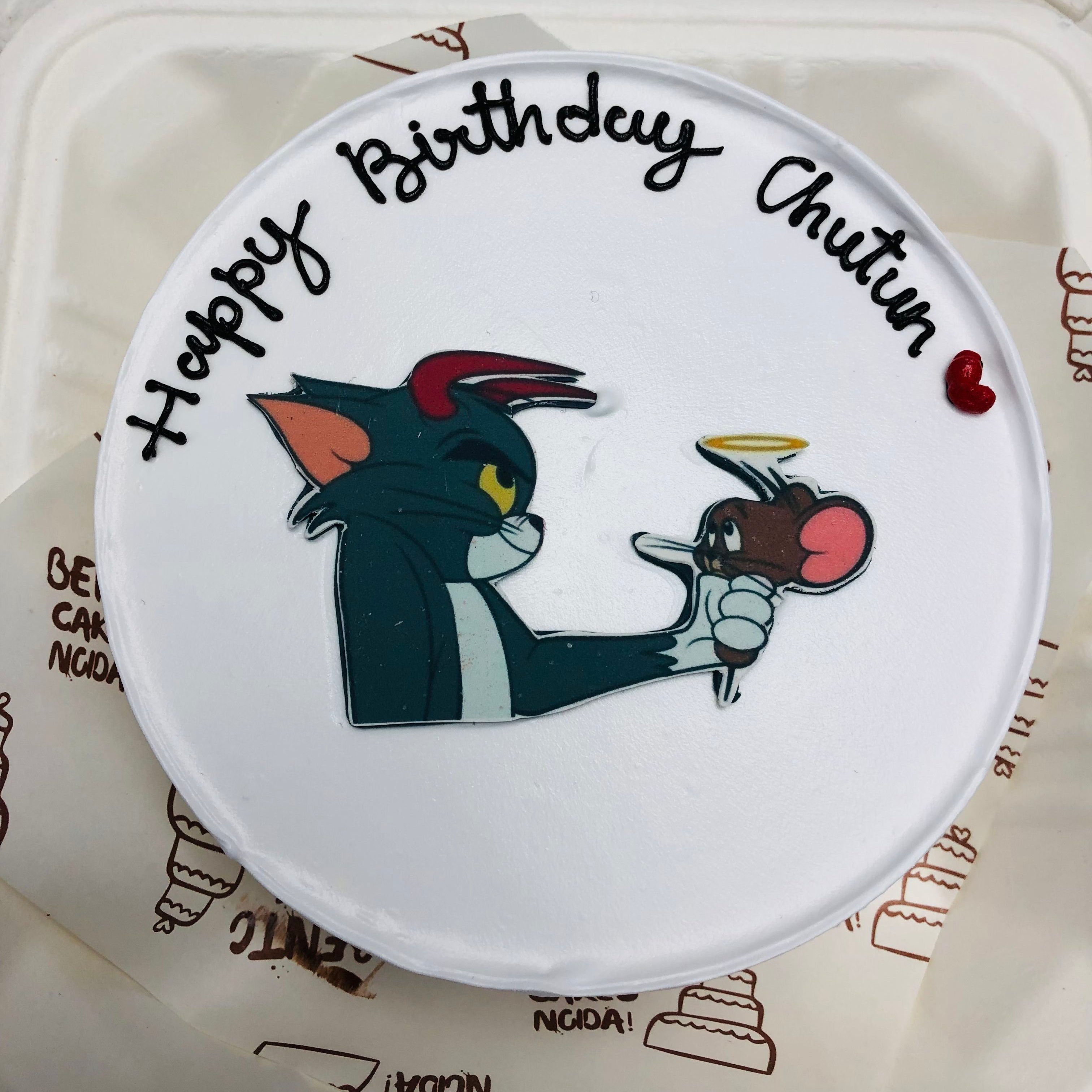 A white bento cake having Tom & jerry cartoon print for birthday.