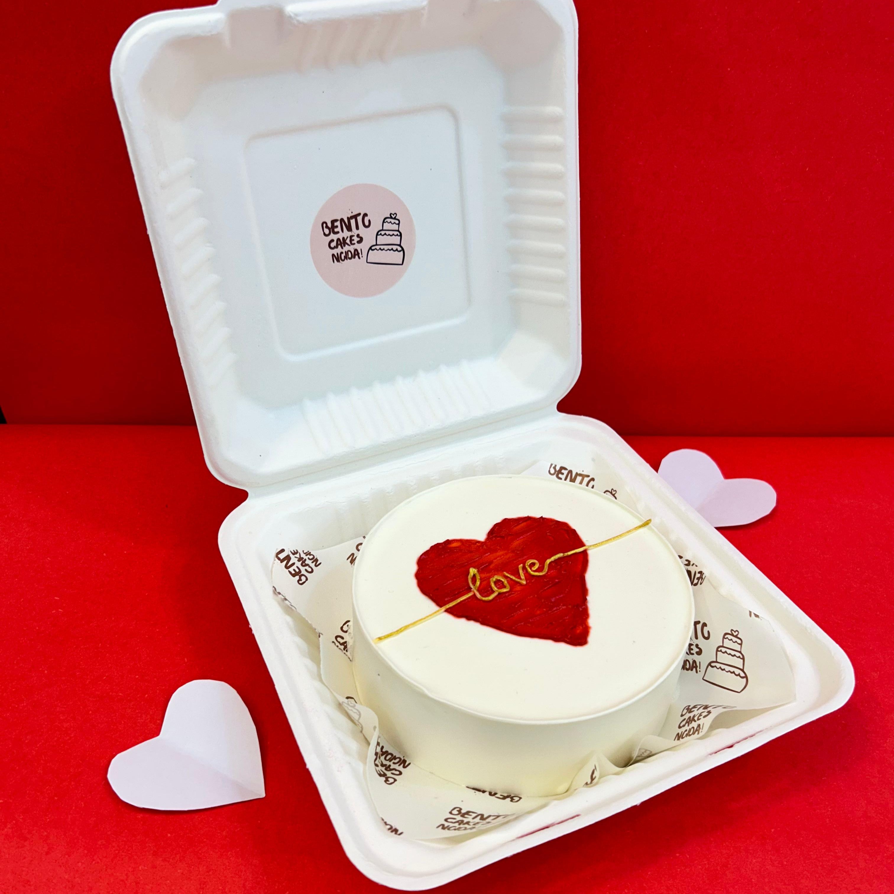 A bento box featuring a red heart design on its surface, symbolizing love and affection from side view.