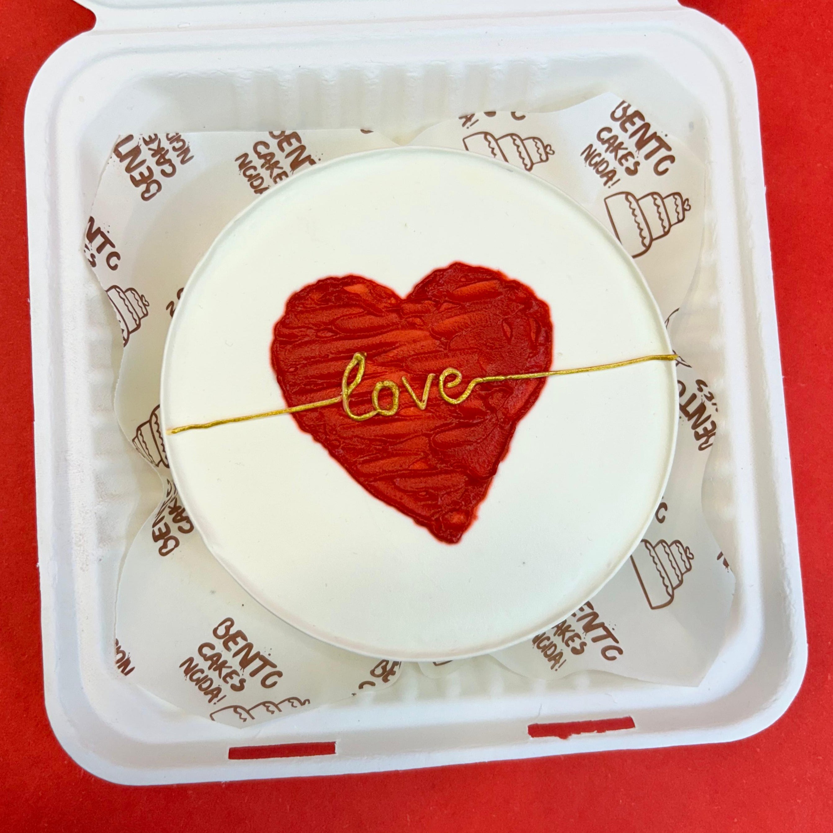 A bento box featuring a red heart design on its surface, symbolizing love and affection from front view.
