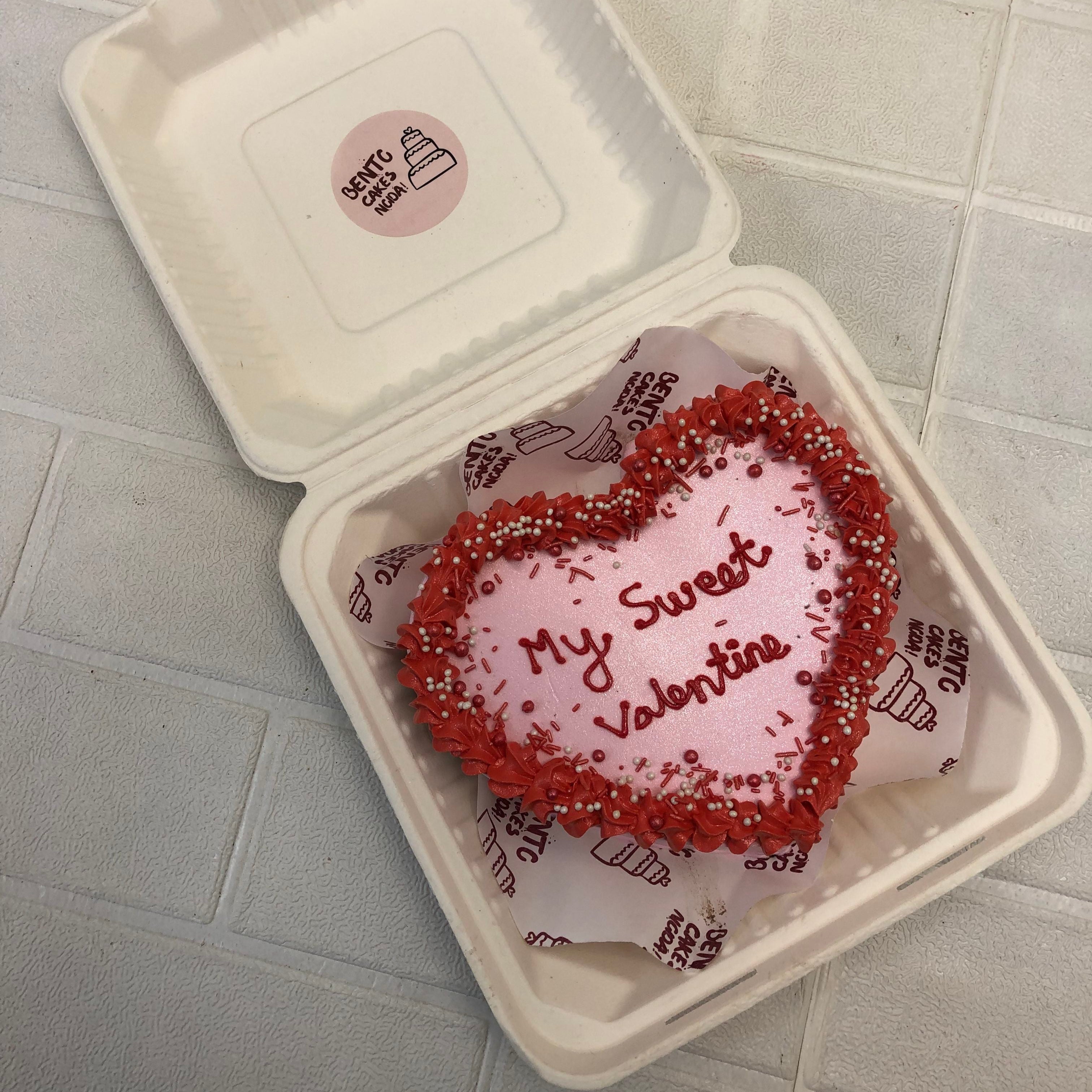 Valentine theme shiny pink color heart shape bento cake with red truffles and red text on it.