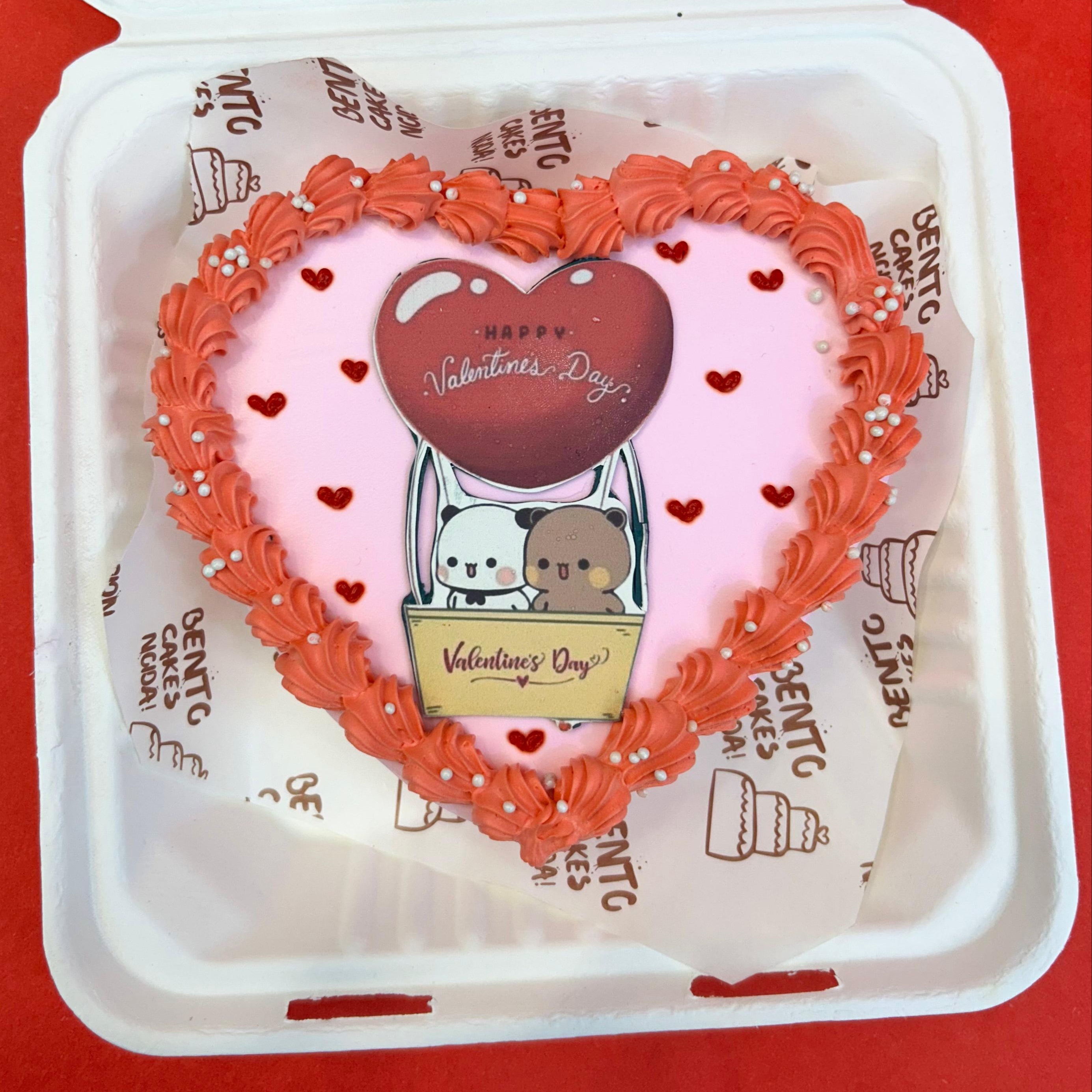 A heart-shaped cake in a bento box with front face, featuring the Bubu Dudu cartoon character, perfect for Valentine's Day.