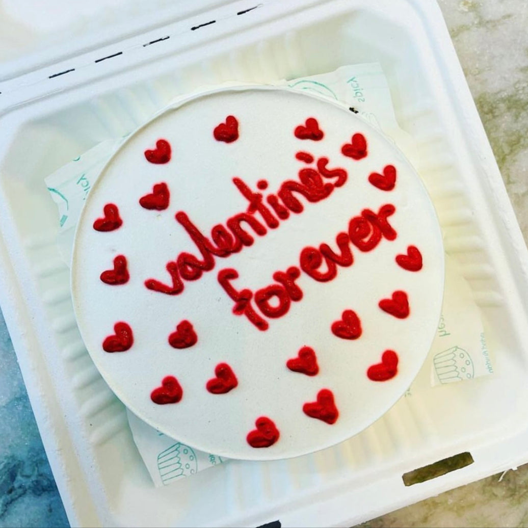 A white box containing a beautifully decorated Valentine's Day cake, perfect for celebrating love and sweetness.