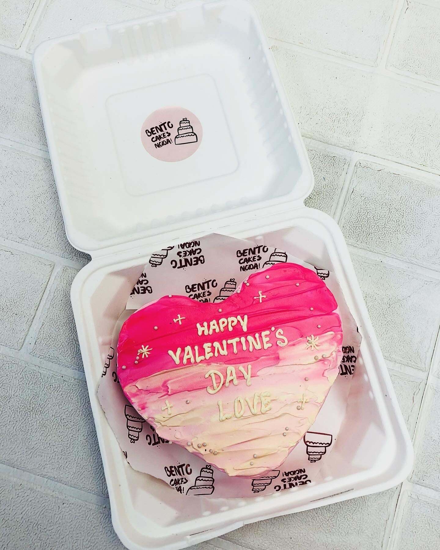 A Valentines Day Theme Pink Color Heart Shape Bento Cake with pink ombe shades on it.