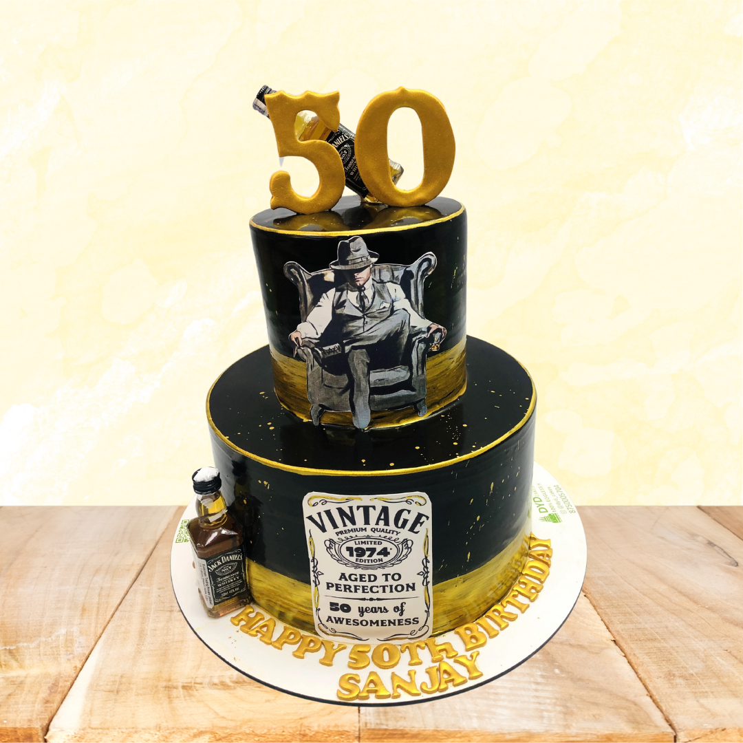 Black golden cake is designed on vintage theme with a jack denials bottle on side and top of the cake with a "50" number on top.