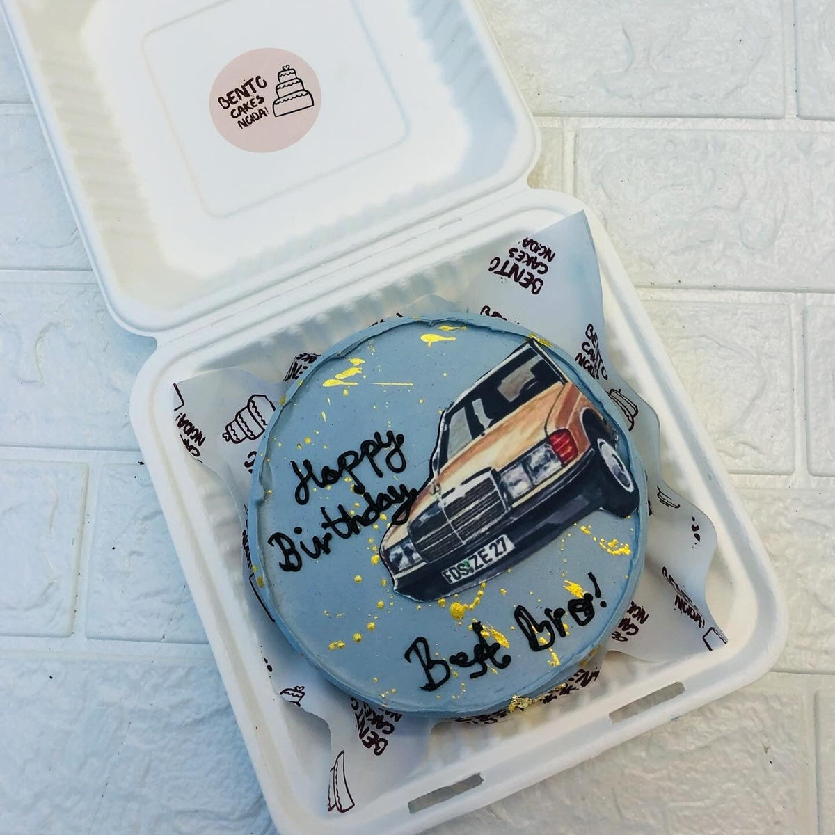 A blue bento cake having a vintage car print.