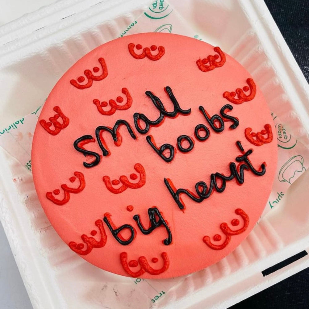 A small cake adorned with text, placed inside a decorative box, ideal for celebrations or gifting.