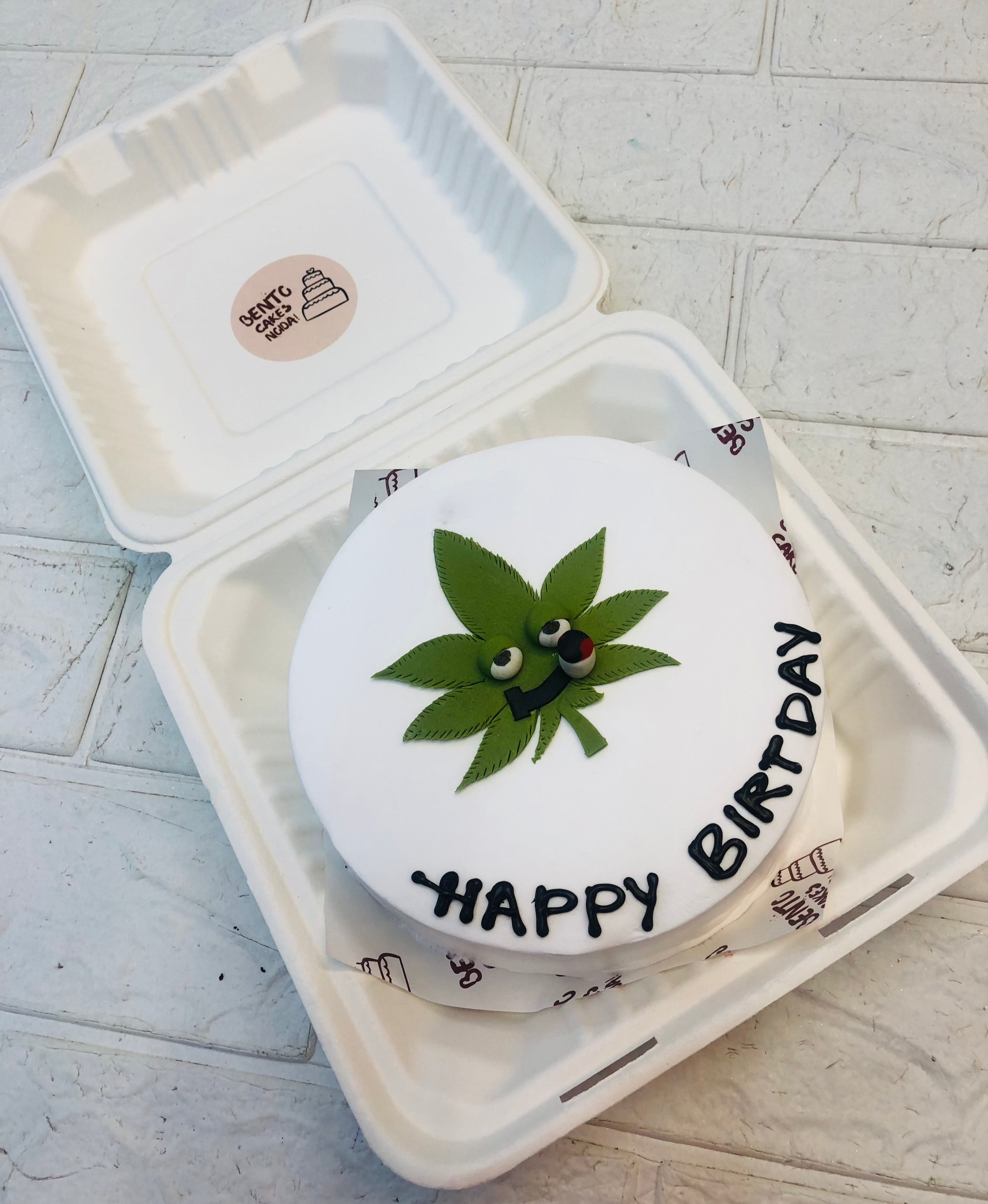 A green color fondant design Weed Leaf on a white bento cake for birthday.