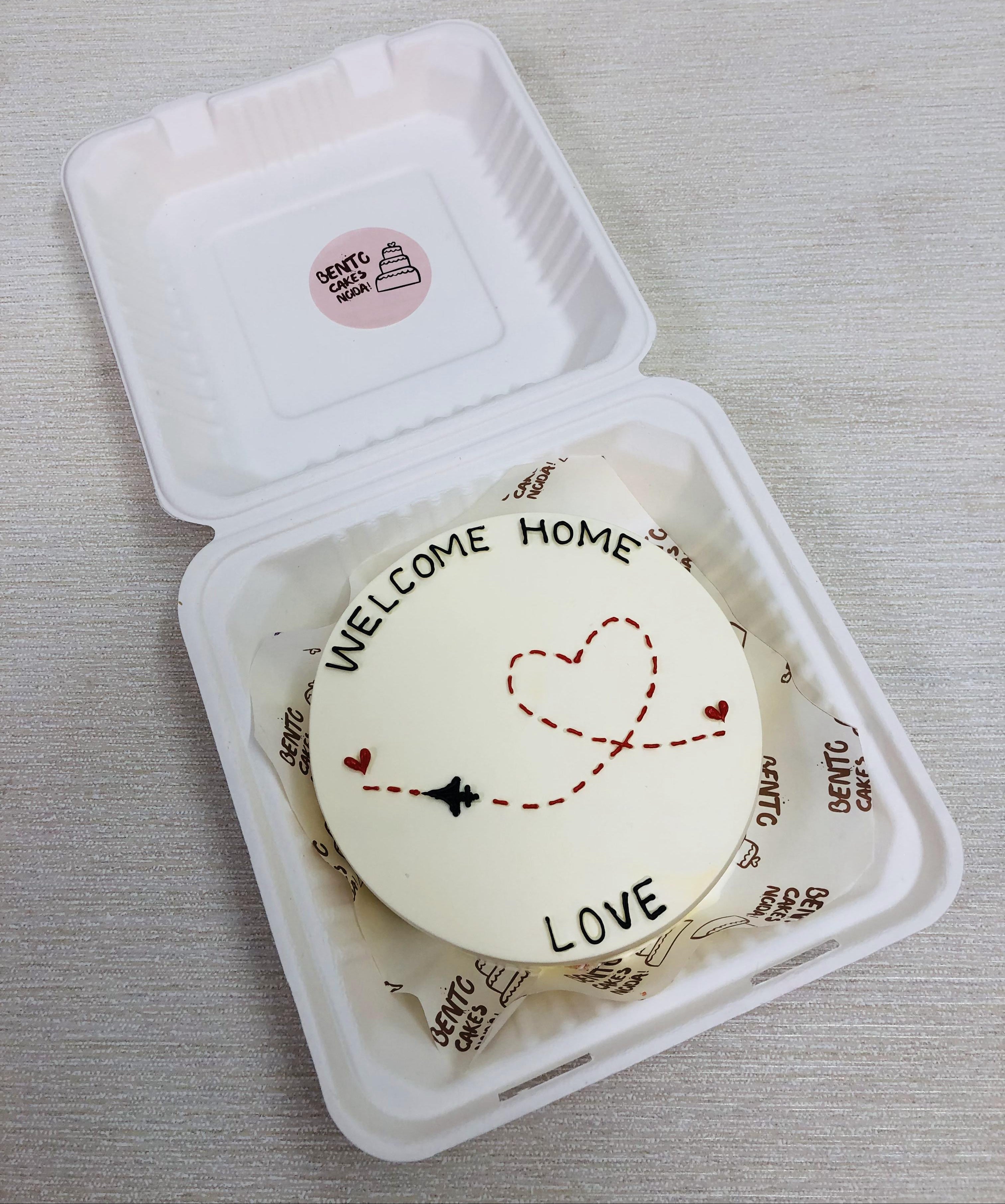 A white bento cake is designed for returning home via flight.