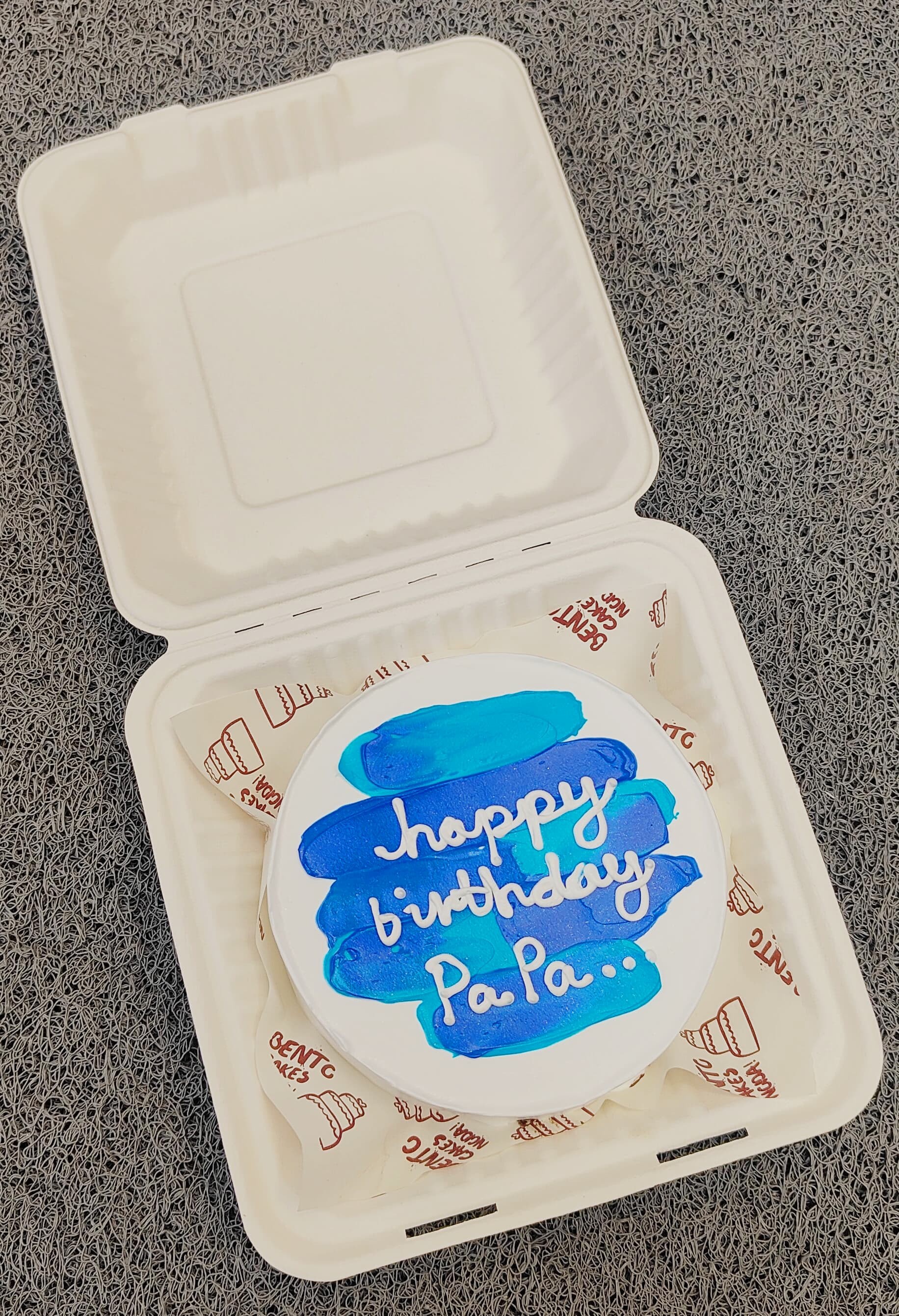 A white bento cake having a blue shades design for fathers birthday.