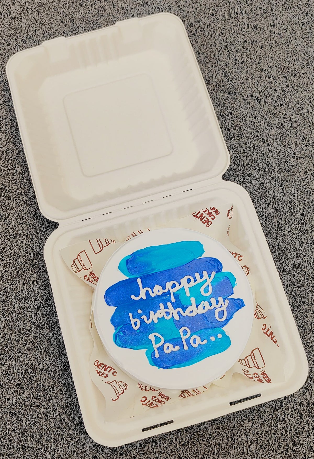A white bento cake having a blue shades design for fathers birthday.