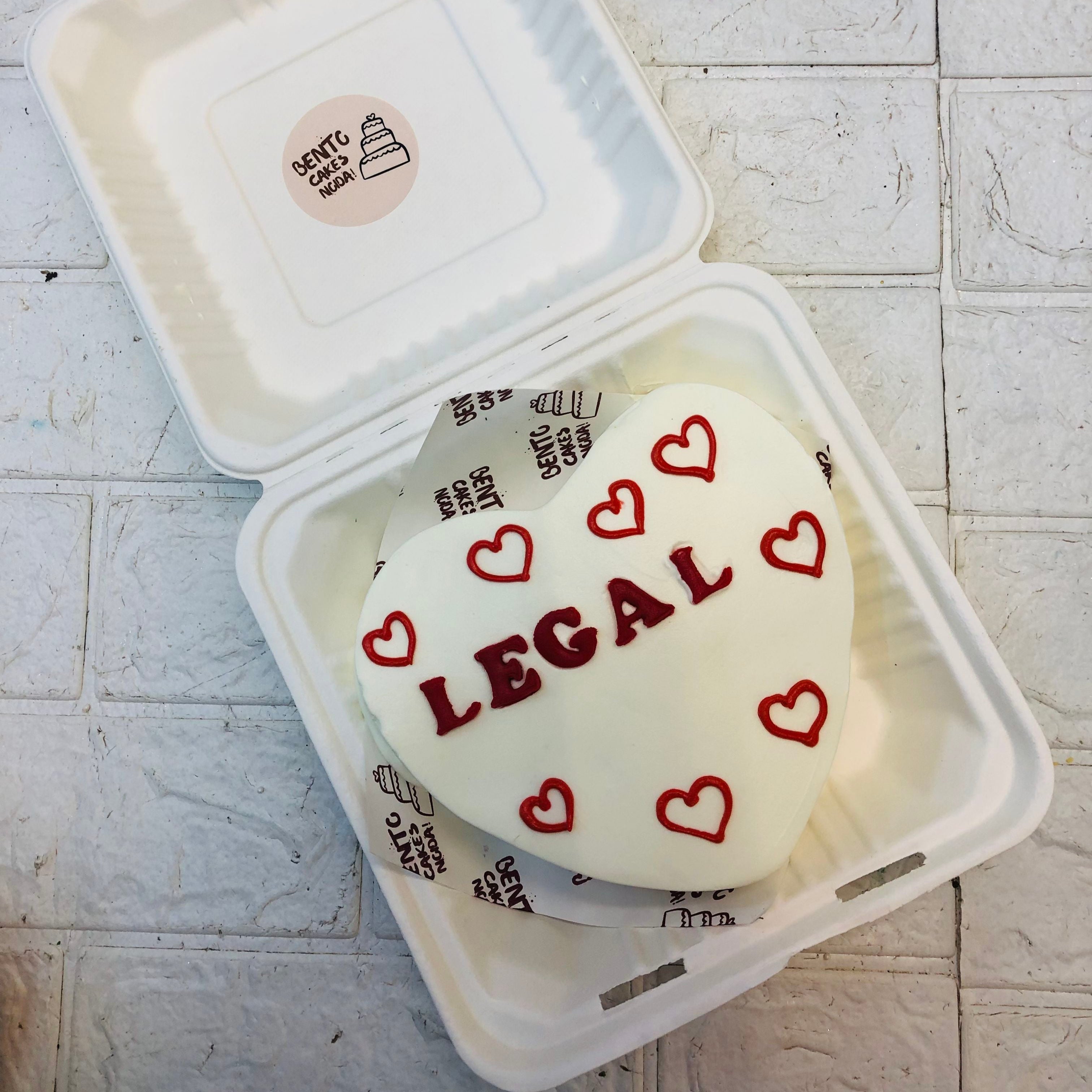 A White Heart shape bento cake with red hearts drawing and a "LEGAL" text written with red fondantalphabet.