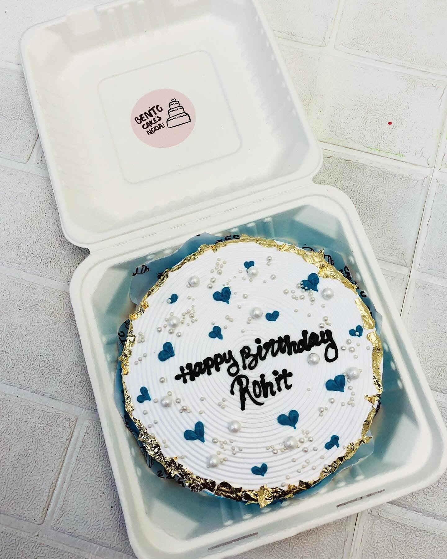 Golden work on aesthetic white bento cake.