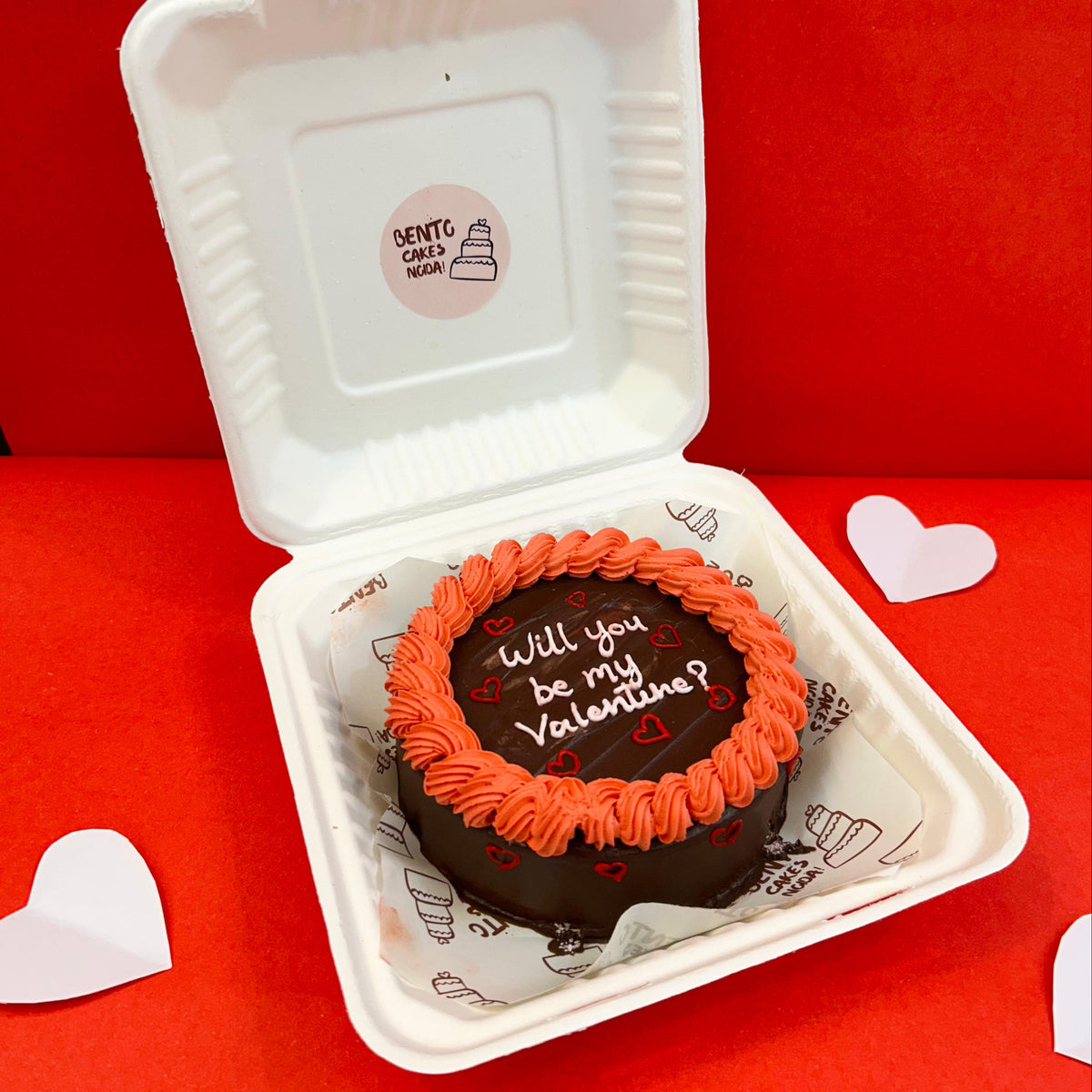 A delightful assortment of donuts in a box, adorned with the phrase, "Will you be my Valentine?" for a romantic touch with side View.
