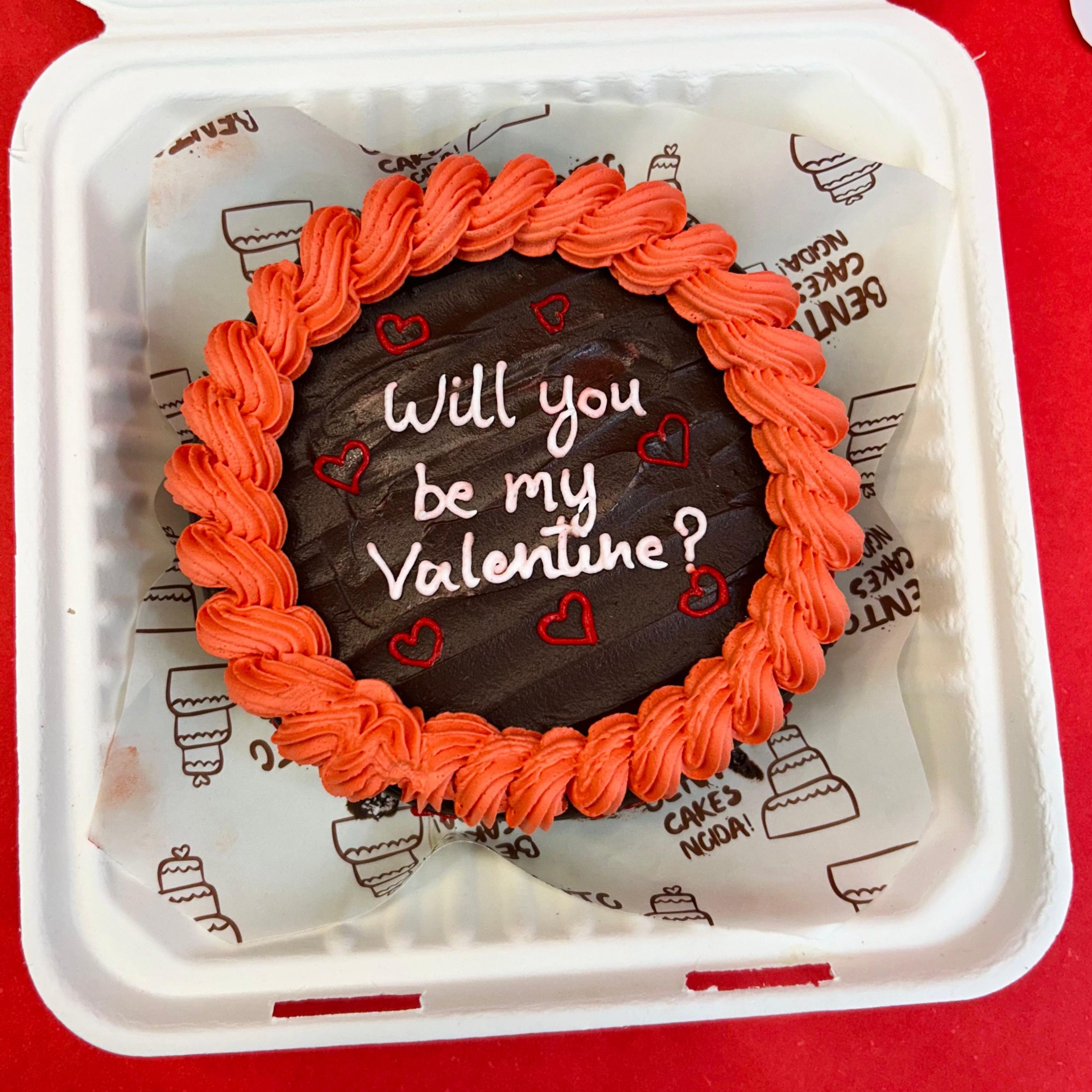 A delightful assortment of donuts in a box, adorned with the phrase, "Will you be my Valentine?" for a romantic touch with Front View.