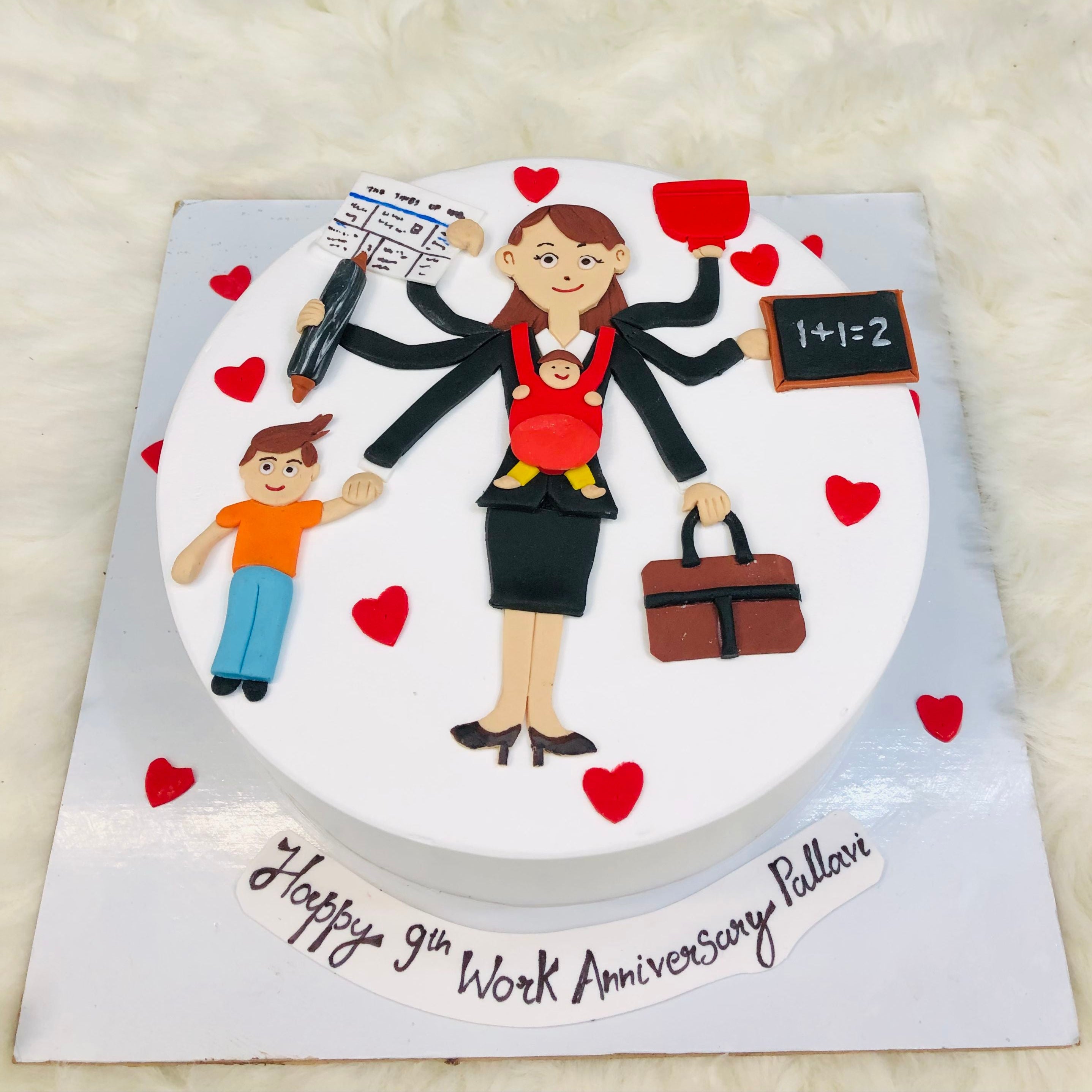 A joyful woman holds a child beside a heart-shaped cake, celebrating love and family moments together from top view.