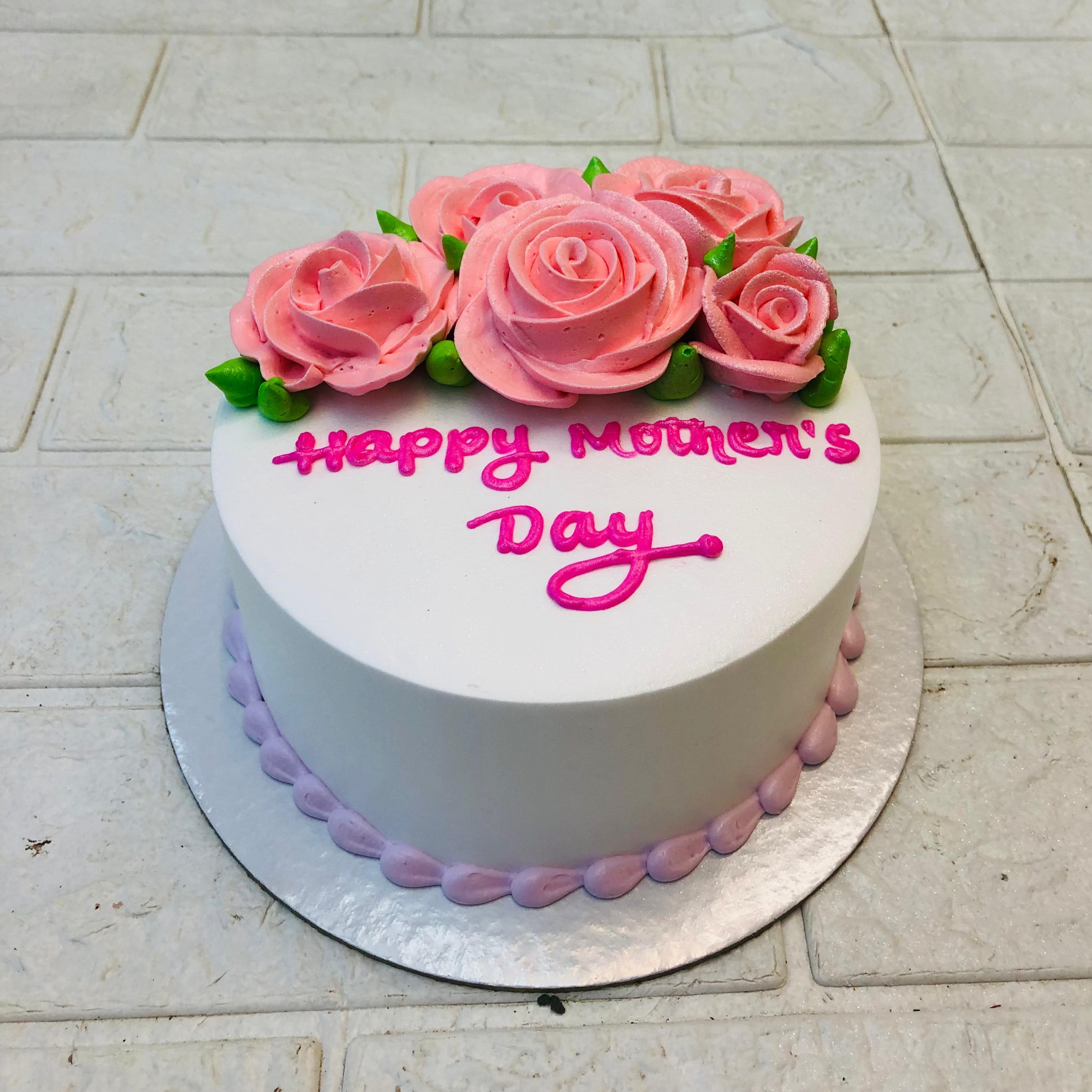 A white cake with pink rosed design with cream texture, specially for mother's day occasion.